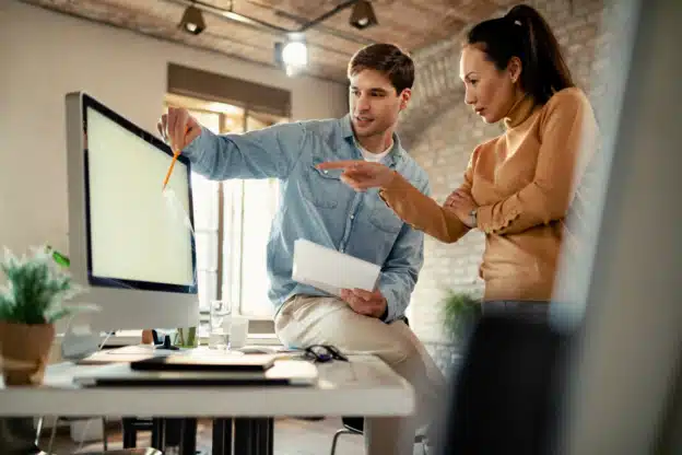 manager et collaborateur devant un ordinateur pour déléguer une mission