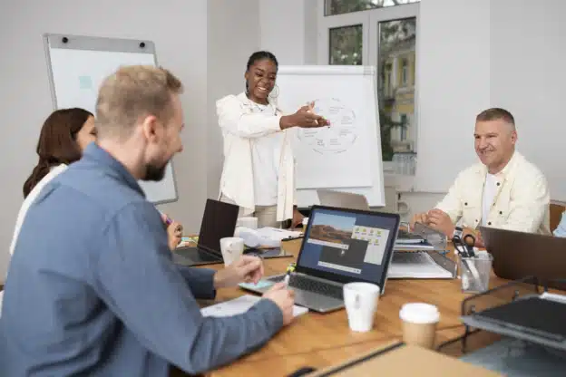 Formateur IA avec trois apprenants dans une salle